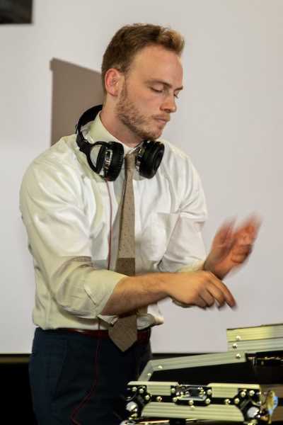 A DJ with headphones on spins a record during a party